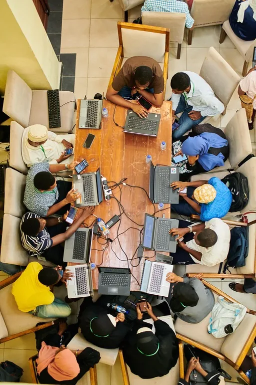 Attendees coding together around shared tables at PyCon Tanzania